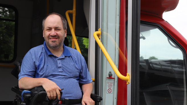 Image of a man on wheelchair next to the Para Transpo bus