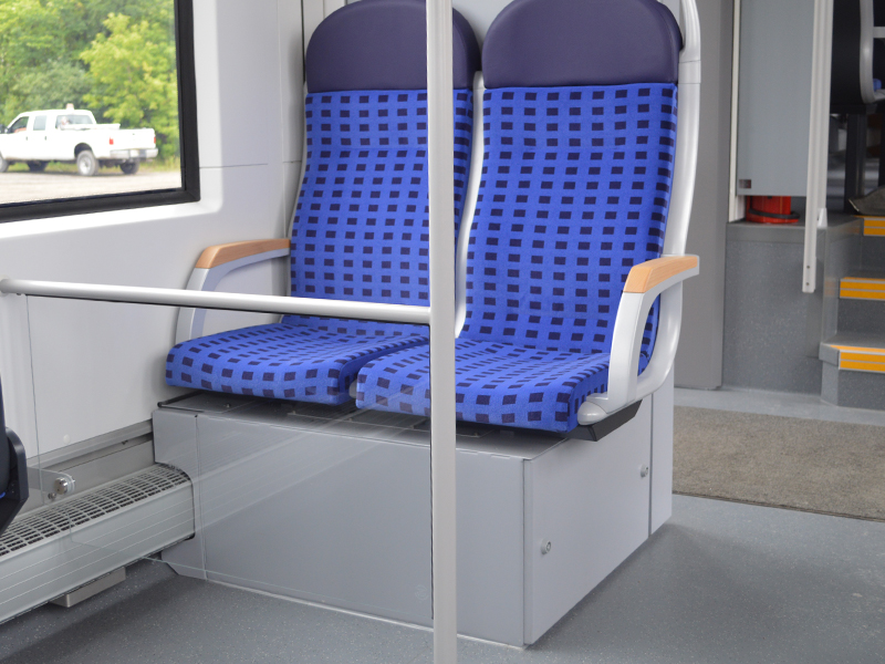 Une image de l’intérieur d’un train LINT montrant les sièges et l’espace pour les fauteuils roulants