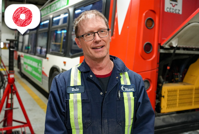 Image - Mécanicien breveté d’OC Transpo devant un autobus dans le garage.