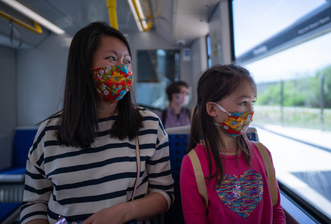Une mère et son enfant portant des masques à bord de l'O-Train
